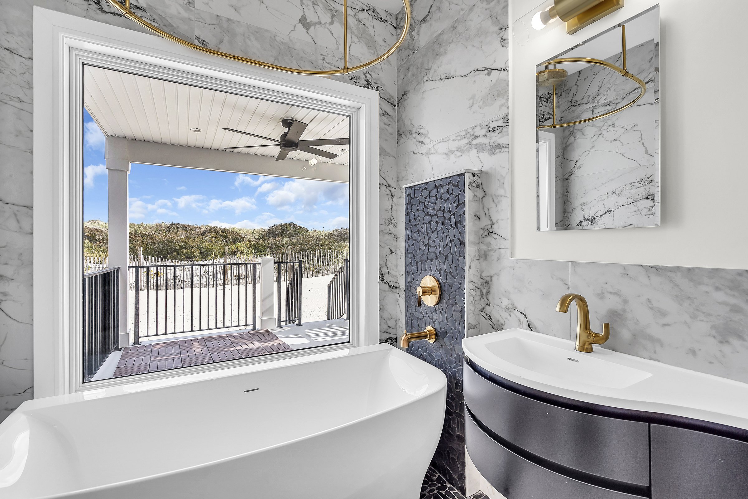 Primary bathroom with marble finishes and brass fixtures at the Wang Residence